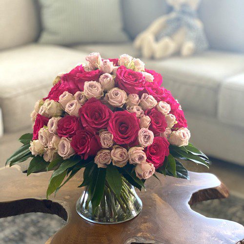 Deep pink and blush roses in a lush dome arrangement on a living room table, premium Raleigh florist